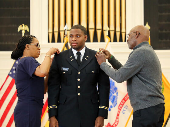 Nicholas Jordan at Commissioning with family adding pins to his uniform.
