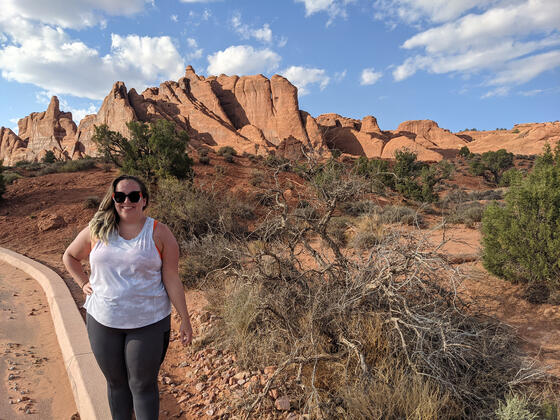 Jenny Sandler, a white woman, stands in Arches National Park.