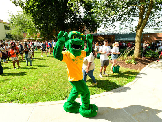 Green Terror Dancing at Orientation with students in the background