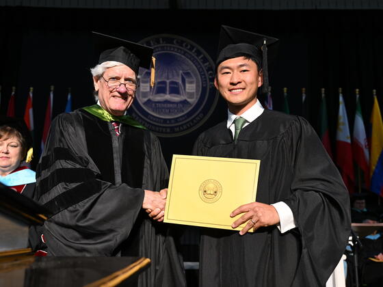 Student in graduation regalia presented an award