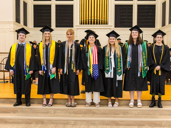 students in regalia pose