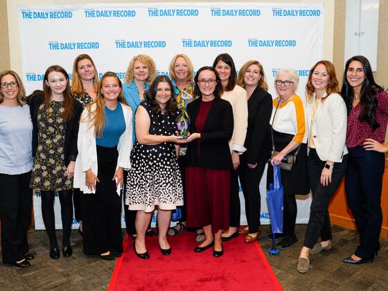 A group photo of McDaniel Women's Leadership Network members, President Jasken, and others, posing with an award at the Empowering Women Awards. 