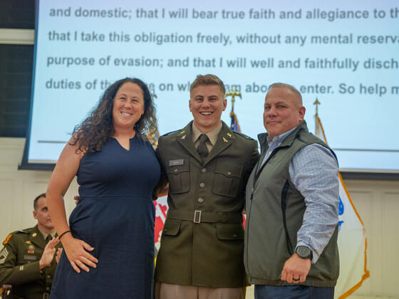 Connor Ward in uniform smiling with his parents at Commissioning.