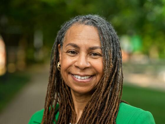 D'Jaris Coles-White smiles outside while wearing a bright green blazer.