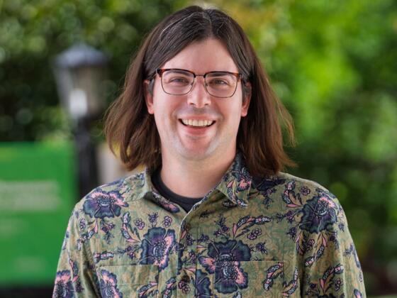 Timothy Swartz stands outside wearing a green paisley shirt.