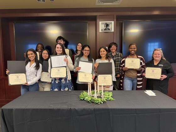 Students standing in a group holding their induction certificates 