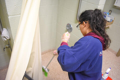 McDaniel freshman Sofia Mendez cleans the bathroom at the Cold Weather Shelter in Westminster on Monday.