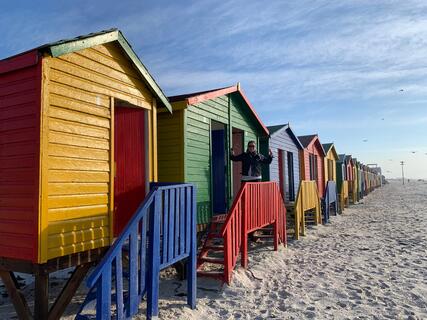 Alumni Jessica Watson in front of beach huts in Cape Town, South Africa.