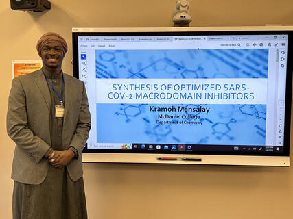 Kramoh Mansalay poses with his presentation for the ISCC conference