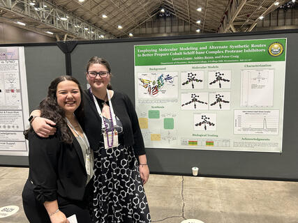 Ashley Reyes and Lauren Logue pose with their presented research poster for the ACS conference