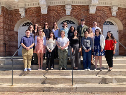 Students standing in a group smiling during their induction
