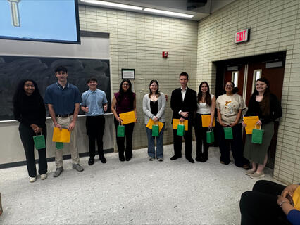 Students standing in a group smiling during their induction