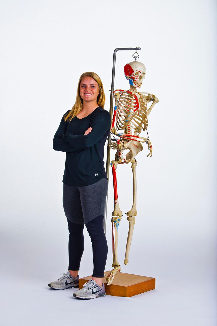 Olivia Maenner standing next to a lab skeleton.