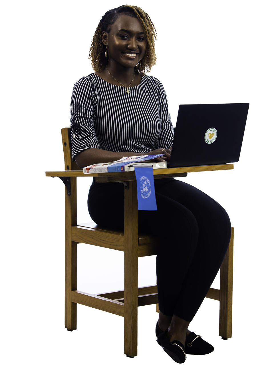 Dalanda Diallo sitting at a desk with a laptop and books.