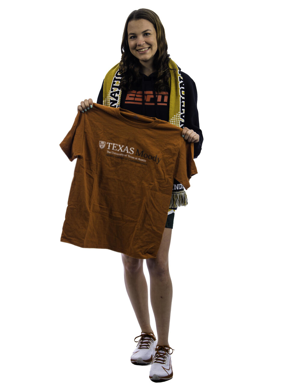 Kaylen Buschhorn poses by a table with a t-shirt for the University of Texas at Austin.