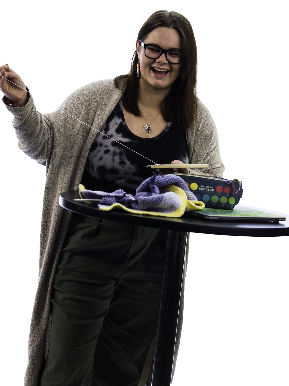 Kaylor Stroot holds a needle and thread while embroidering at a table.