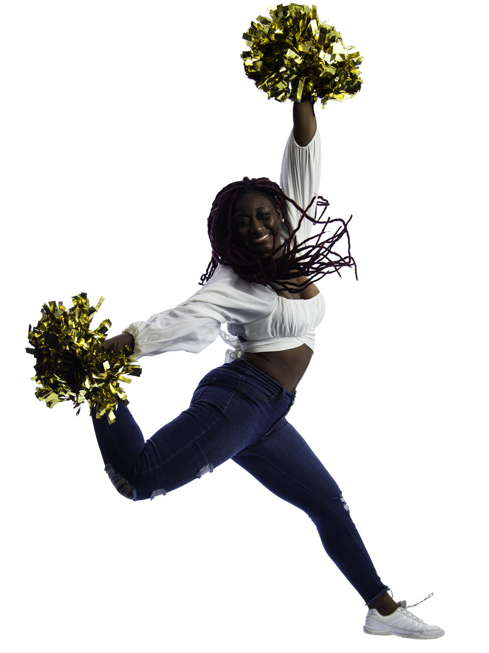 Tracey Ackah jumping in the air with two gold pompoms.