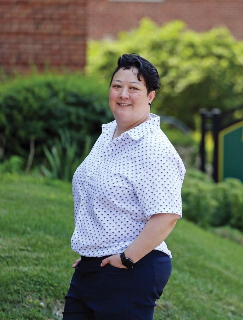 Photo of professor Shana Joslyn standing outdoors in front of green bushes.