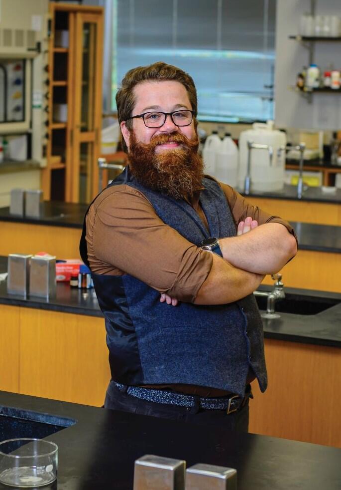 Photo of professor Ben Smith standing in a science lab with arms crossed.
