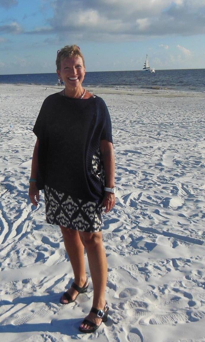 Photo of professor Kathi Hill standing on a beach.