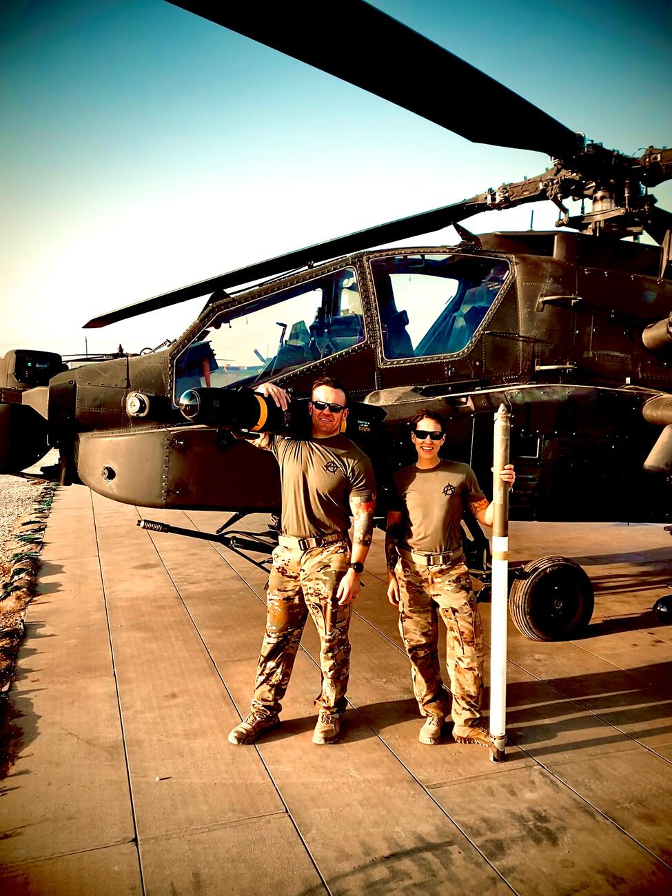 Nick and wife Meghan Giusti stand in front of a helicopter in Syria.