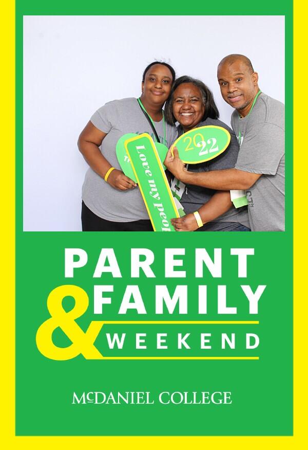 A mother and father pose with their daughter for a photobooth photo.
