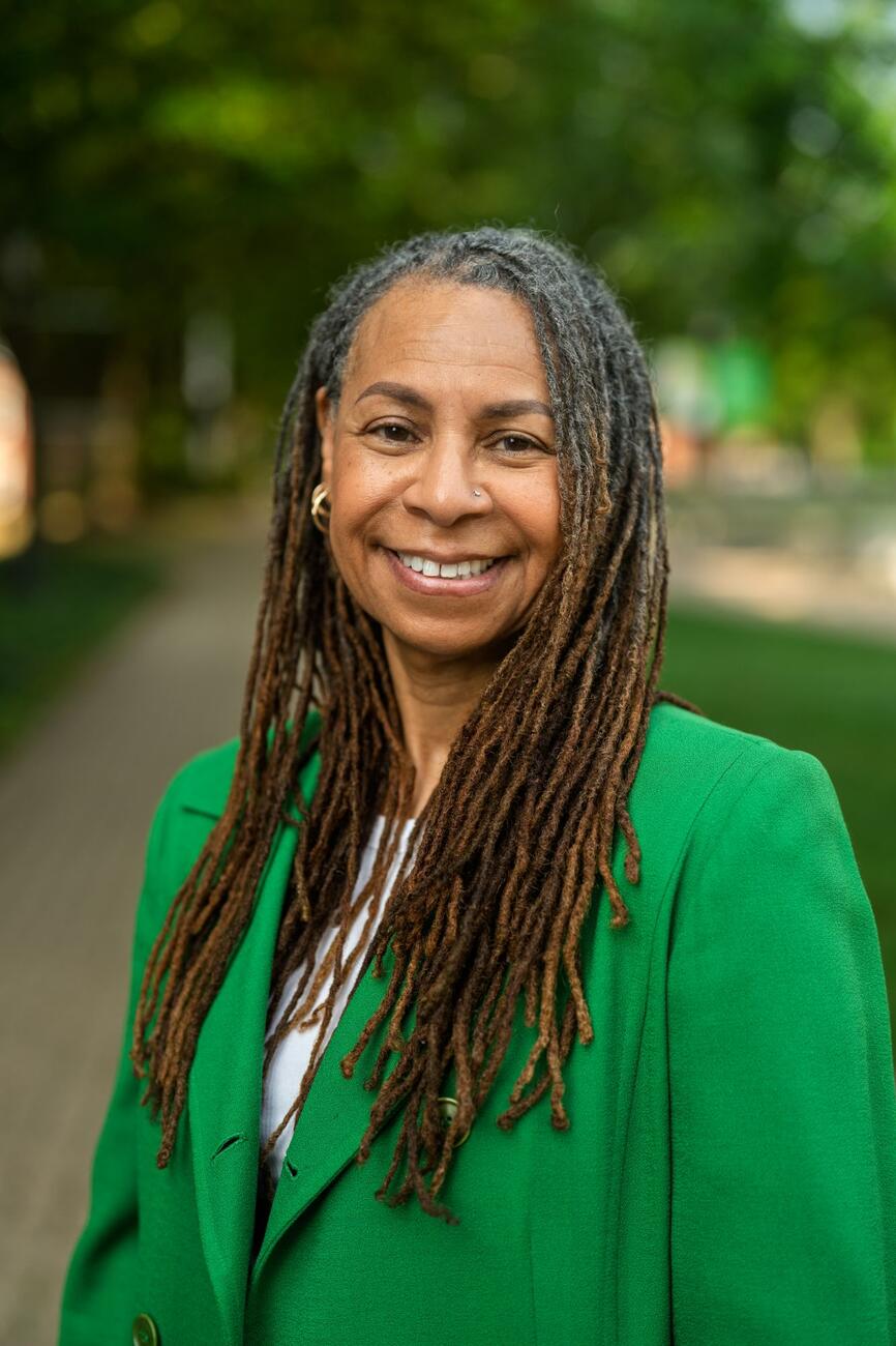 D'Jaris Coles-White smiles outside while wearing a bright green blazer.