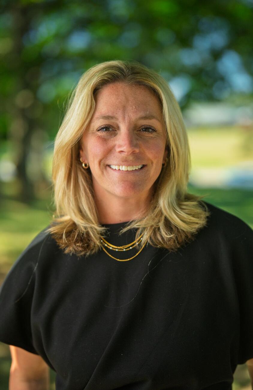 Rachel Guilfoyle smiles outside while wearing a black blouse.