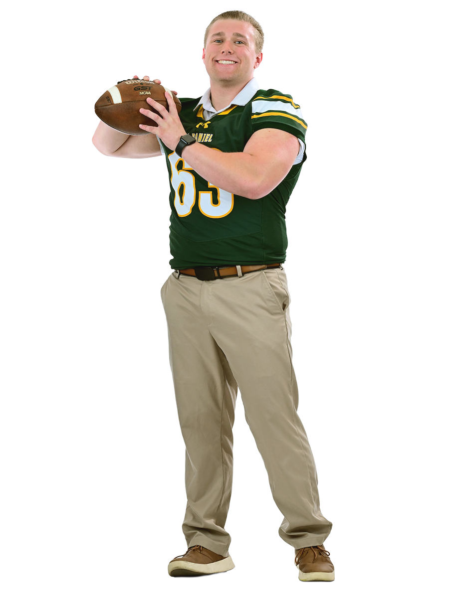 A male student wearing a football jersey prepares to throw a football.