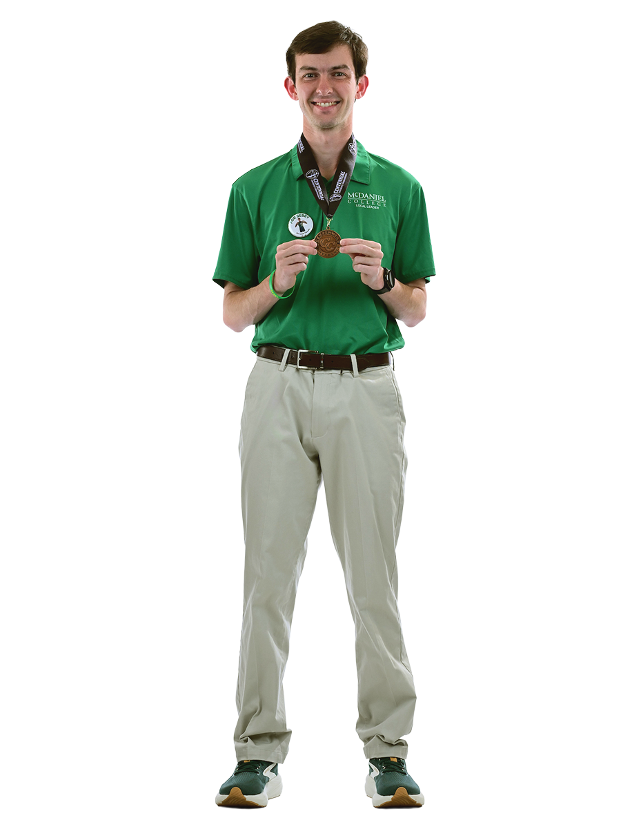 A male student in a McDaniel polo shirt wears and holds a gold medal.