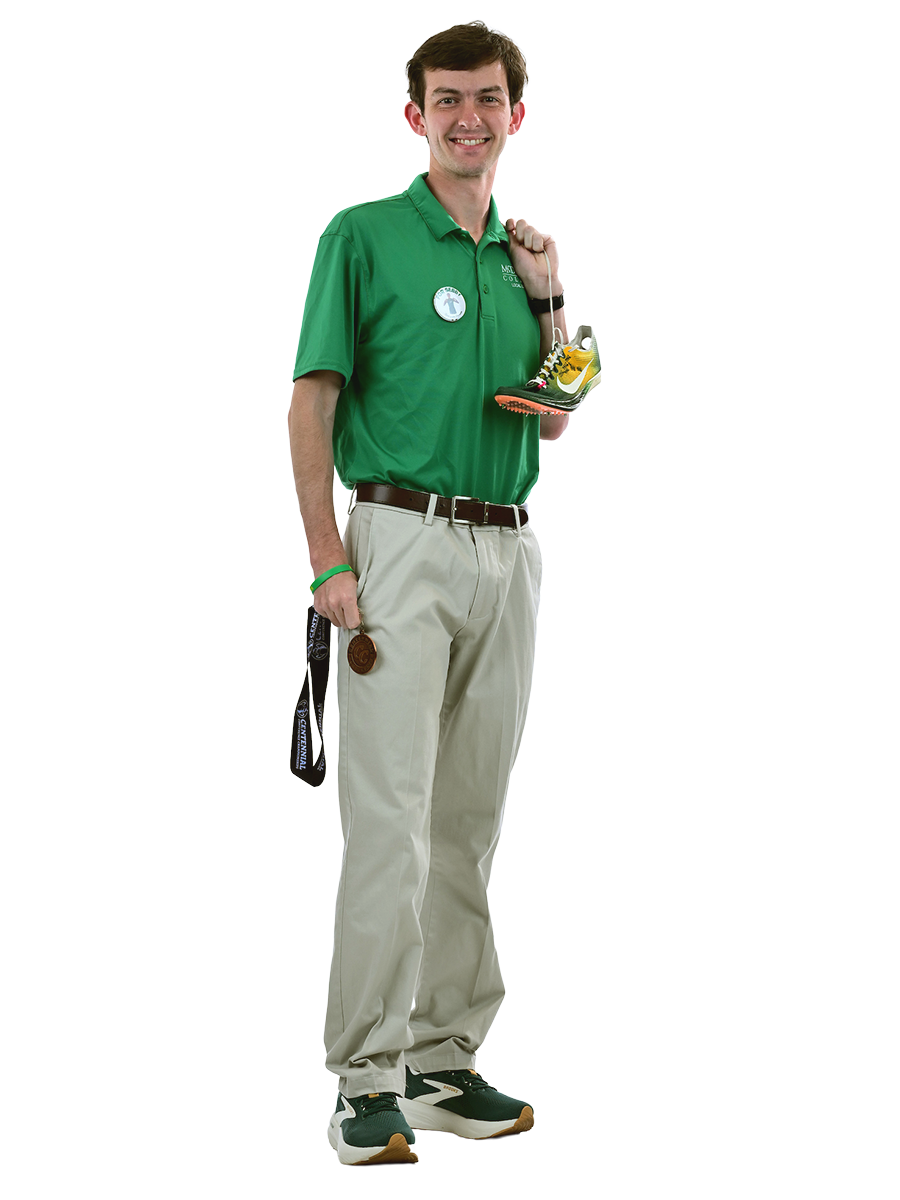 A male student in a McDaniel polo holds a gold medal and track shoes.