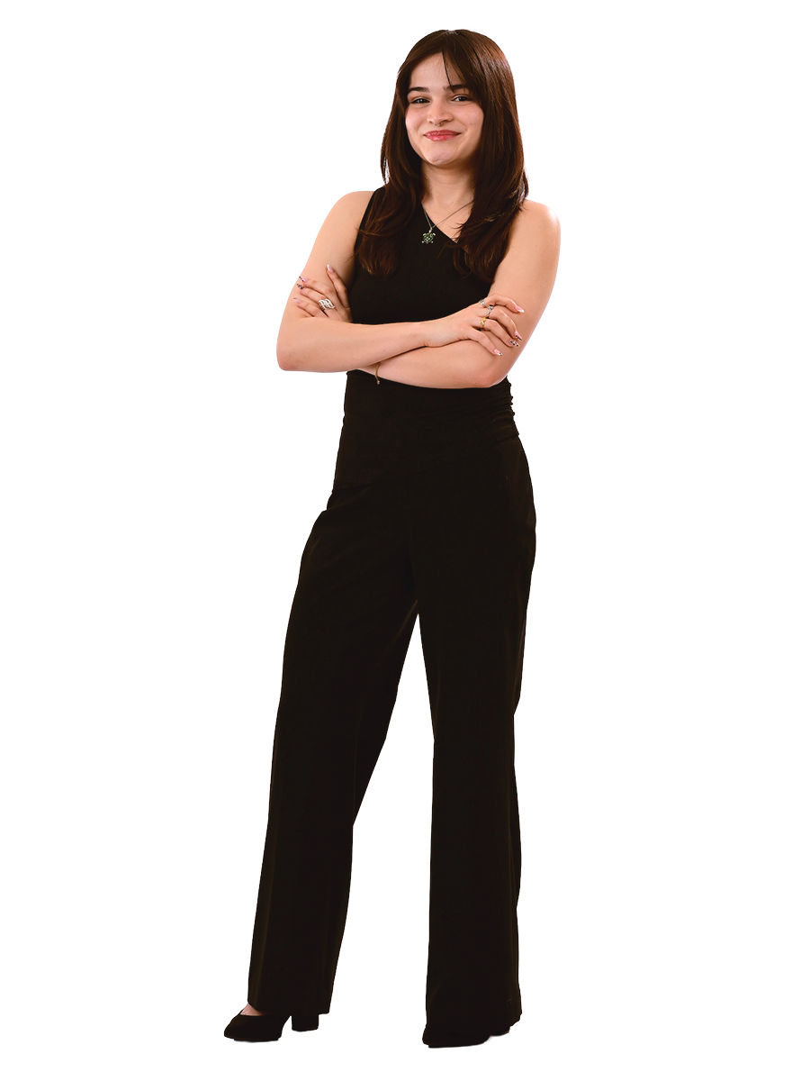 A female student wearing all black stands with her arms crossed.