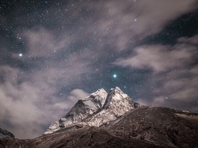 Clouds and stars over a mountain