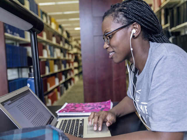 Student on computer in Hoover Library.