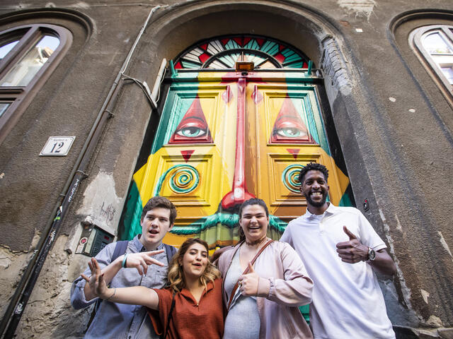 Students standing in front of painted doors in Budapest.