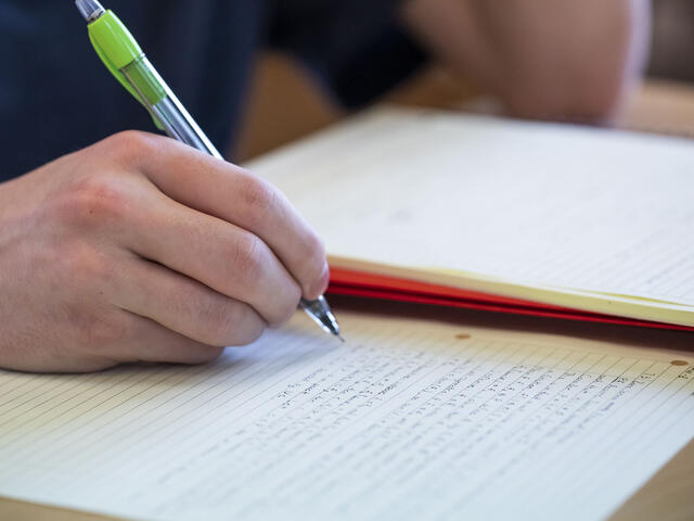 Student writing in notebook.