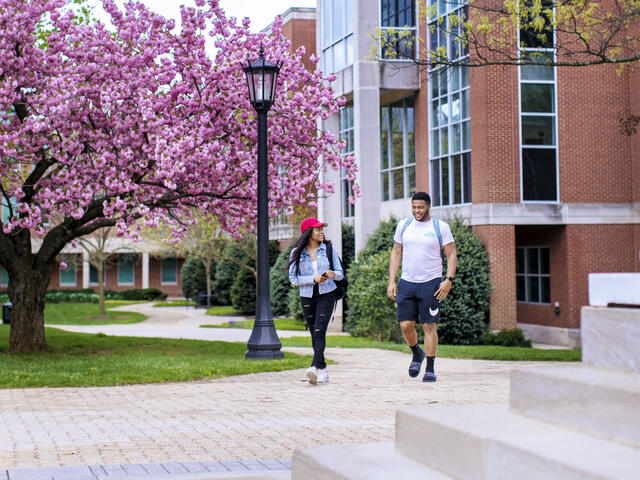 Two students walking across campus.