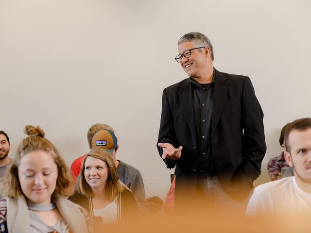 Professor with students in classroom.