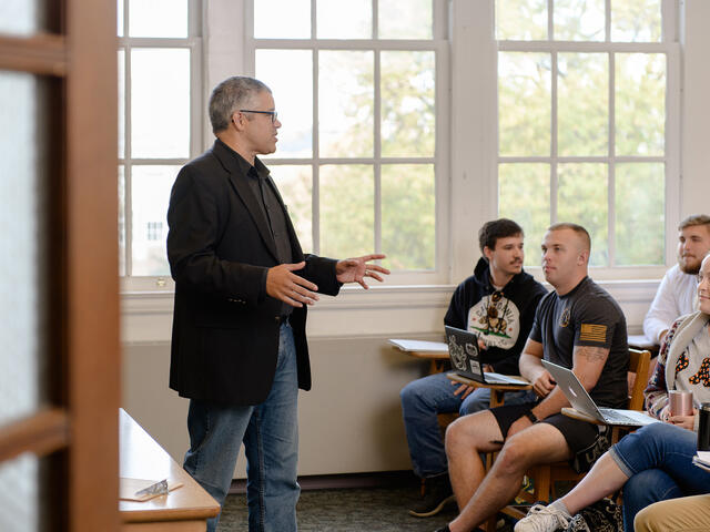 Professor lecturing in front of class.