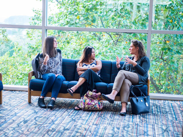 Grad students in conversation in lobby.
