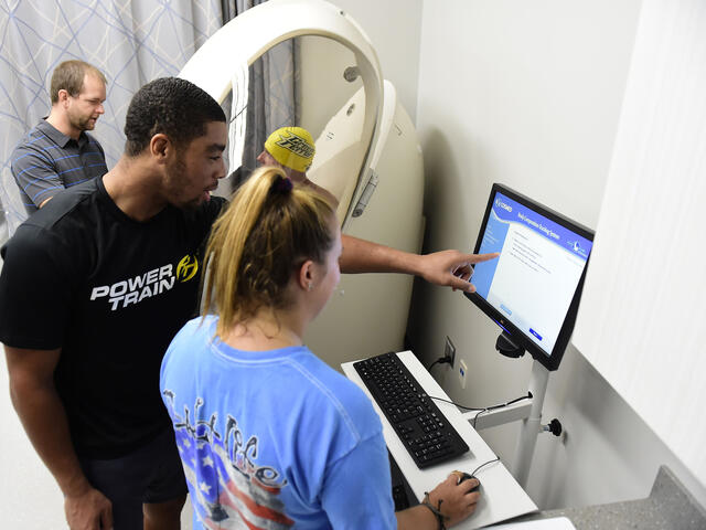 Students with professor in Kinesiology lab.