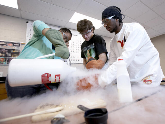 Three students conducting an experiment.