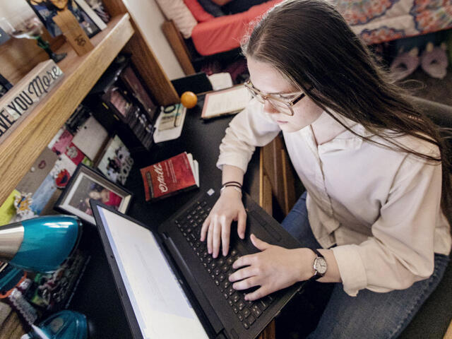 Students on computers in residence hall room.