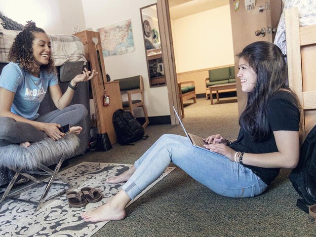 Students on computer in residence hall room.