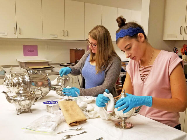 Students cleaning silver.