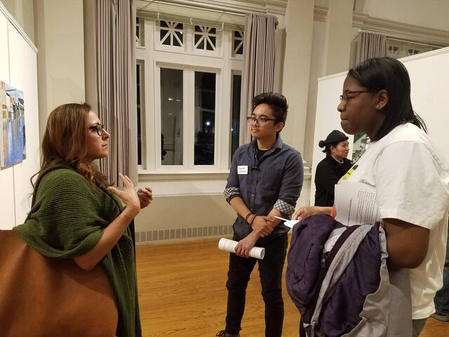 Students talk to an alum at a networking event. 