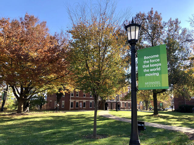 McDaniel College campus in Fall with Keep the World Moving banner