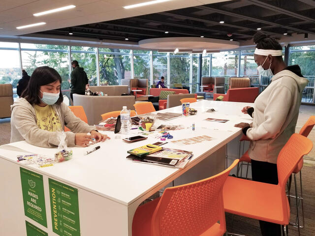 Two students use craft materials in Roj Student Center.