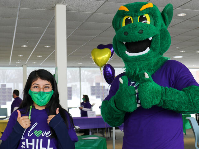 Melissa Torres '24 smiles with the Green Terror on the third annual I Love the Hill Day.