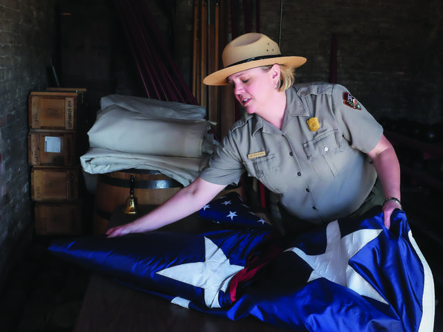 Abbi Wicklein-Bayne folding the American flag while wearing her ranger uniform.